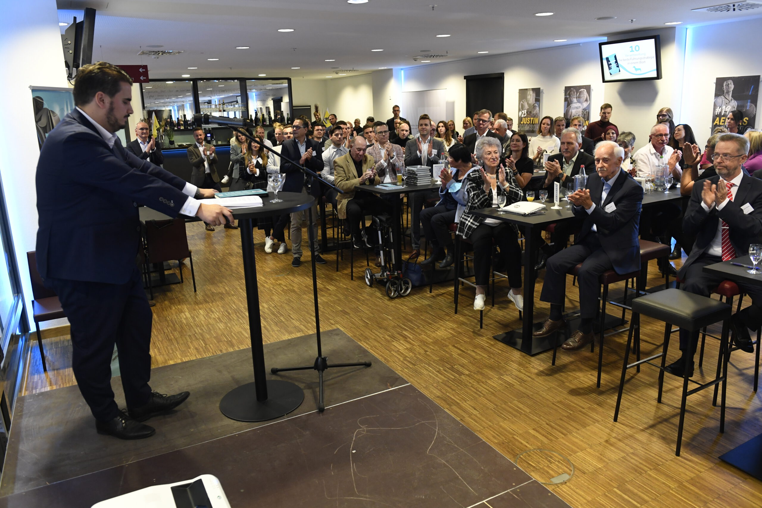 Der Speaker Tobias Epple auf der Bühne vor Publikum